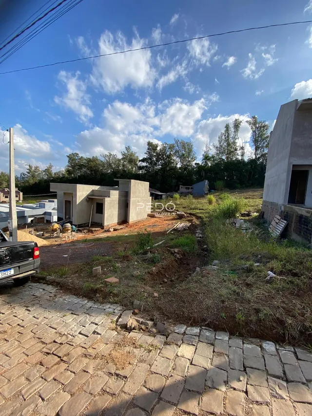 Vista externa de uma propriedade em construção em Lajeado, Brasil, com terreno e estruturas em concreto.