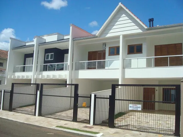 Fachada de uma casa residencial branca com muro e portão preto em Lajeado, Brasil.