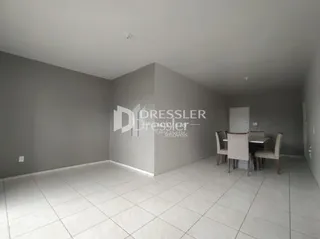 Imagem de uma sala interna com paredes cinzas e piso de cerâmica clara.