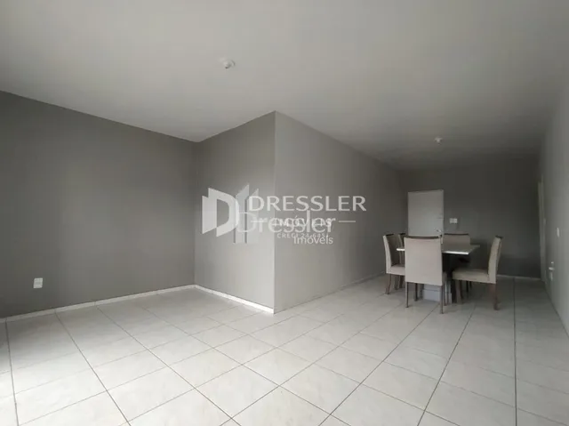 Imagem de uma sala interna com paredes cinzas e piso de cerâmica clara.