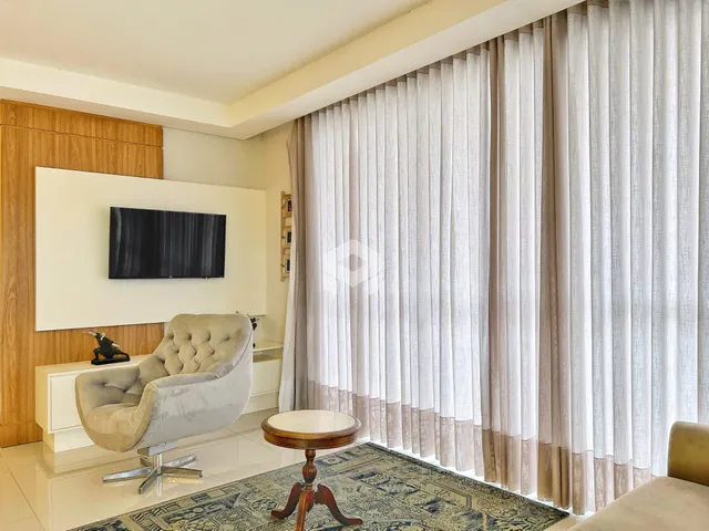 Sala de estar com cortinas e decoração moderna em um imóvel no Brasil.