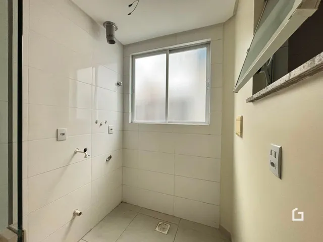 Foto de um banheiro interno com paredes brancas e piso claro.