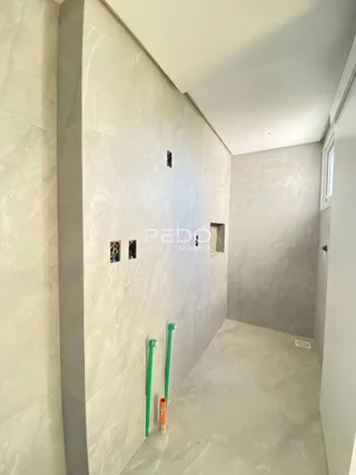 Vista interna de um corredor com paredes claras em um imóvel.