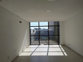 Vista interna de um ambiente com grandes janelas de vidro.
