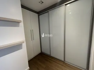 Quarto com armários embutidos e piso de madeira.