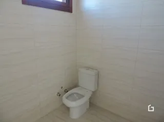 Foto de um banheiro com azulejos brancos e um vaso sanitário.