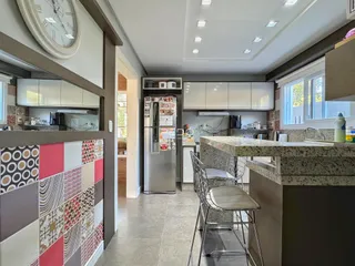 Cozinha moderna com bancada de granito e armários brancos.
