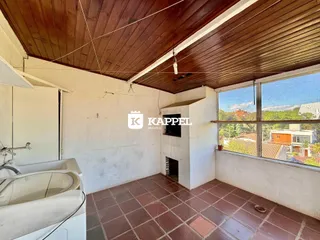 Foto interna de um banheiro com banheira e piso de ladrilho.