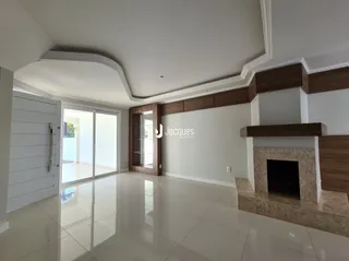 Interior de uma sala de estar com piso de cerâmica e detalhes em madeira.