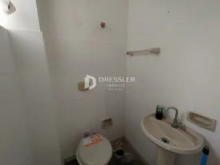 Foto de um banheiro interno com azulejos brancos e vaso sanitário.