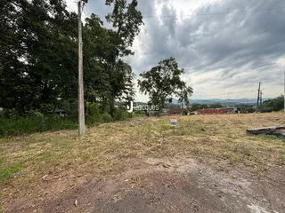 Vista de uma área de terreno aberto com vegetação e campo seco.