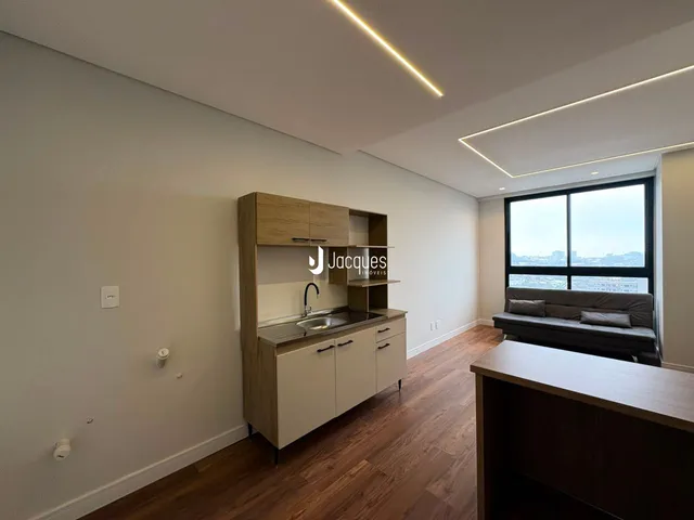 Ambiente interno de um apartamento moderno com piso de madeira e iluminação em LED.