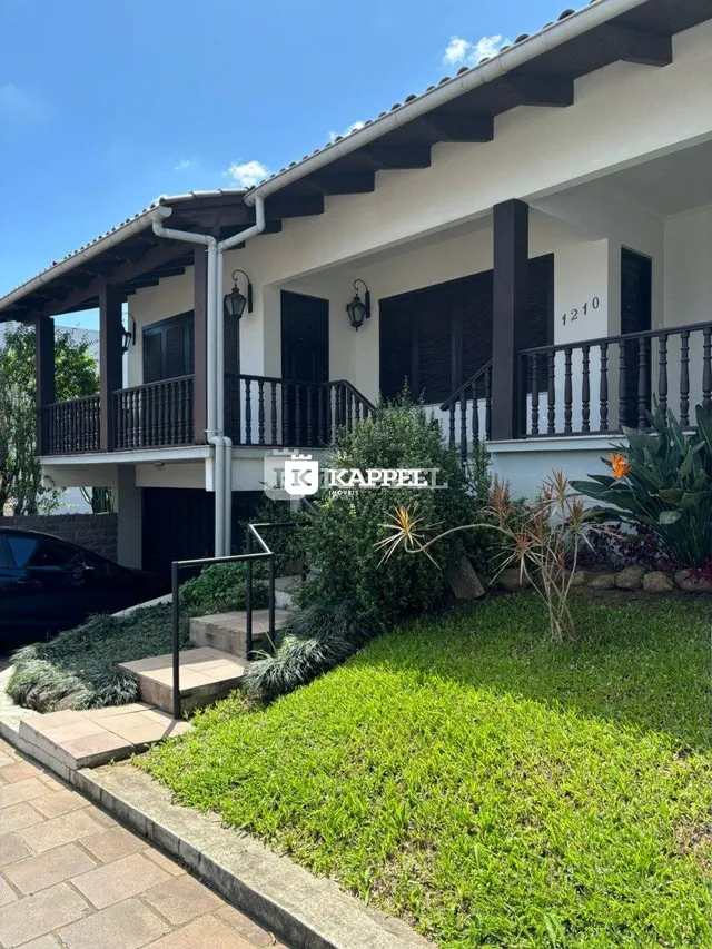 Fachada de uma residência em Lajeado, Brasil, com varanda e jardim bem cuidado.