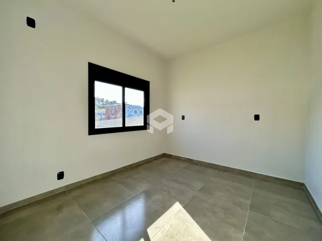 Uma sala com paredes brancas e piso de cerâmica.