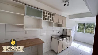 Foto de uma cozinha com armários brancos e piso de cerâmica.