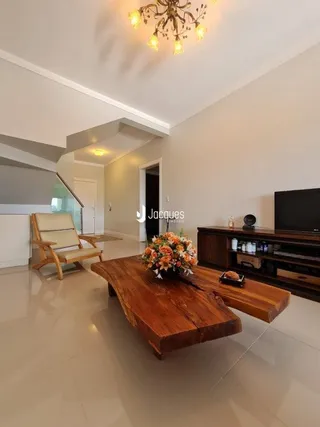 Sala de estar com piso claro e móveis de madeira.