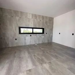 Foto de um ambiente interno amplo com paredes de concreto aparente e piso de concreto.