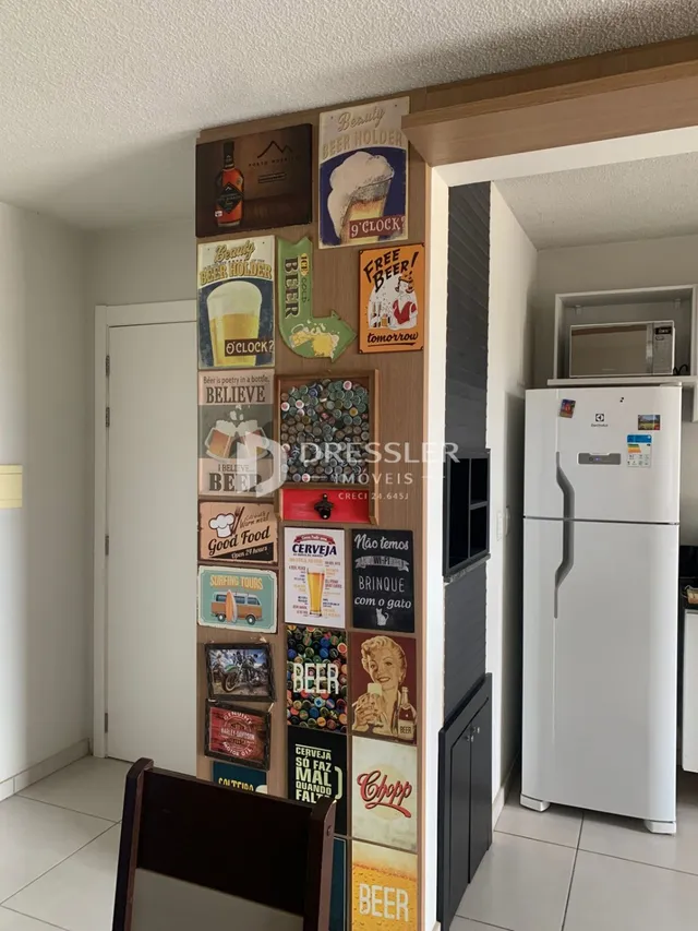 Vista de um corredor interno com decoração de pôsteres em uma residência.