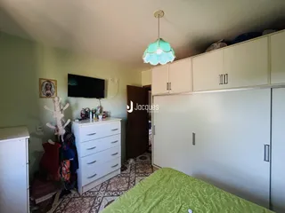 Quarto com armários embutidos e cama em primeiro plano.