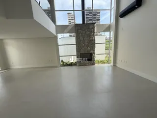 Sala de estar ampla com grandes janelas que dão vista para o exterior.