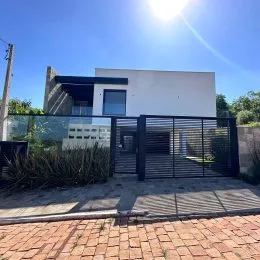 Fachada moderna de uma residência em Lajeado, Brasil, com cerca de metal na frente.