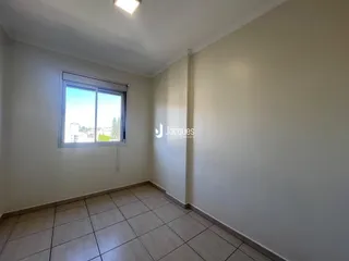 Vista interna de uma sala com piso de cerâmica e janela.