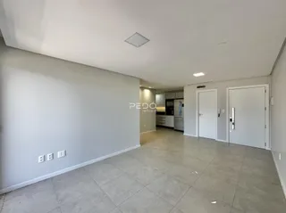Espaço interno amplo com piso de cerâmica e paredes brancas.
