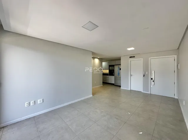 Espaço interno amplo com piso de cerâmica e paredes brancas.