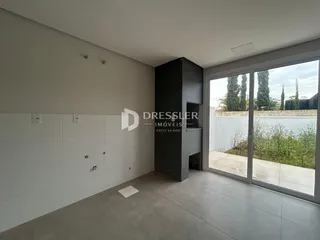 Interior de uma sala com paredes brancas e piso cinza claro.