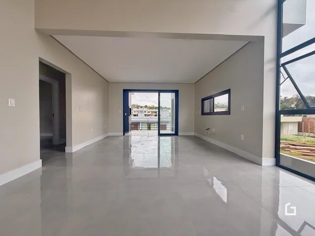 Ambiente interno amplo com piso de concreto polido e porta de vidro.