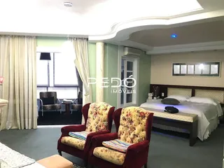 Quarto com decoração clássica e cortinas claras em uma residência no Brasil.