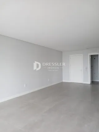 Ambiente interno de uma sala com paredes brancas e piso cinza claro.
