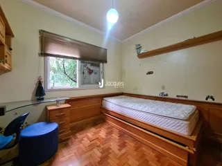 Quarto com cabeceira de madeira e piso de madeira.