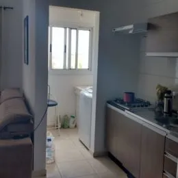 Foto interna de uma cozinha com armários e janela.