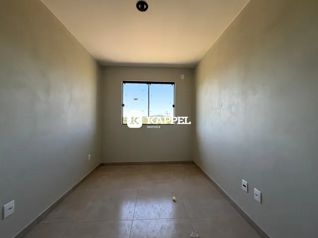 Foto de um cômodo interno com paredes claras e piso de cerâmica.