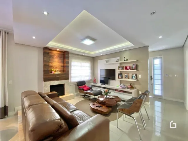 Sala de estar com sofá de couro e lareira em um imóvel.