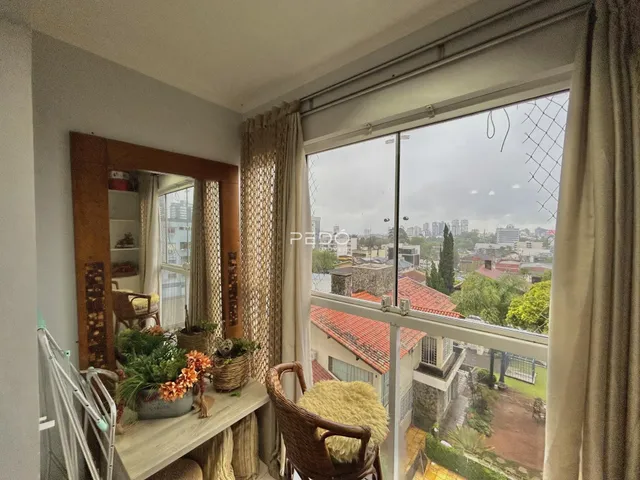 A sala de estar apresenta uma grande janela com vista para a paisagem urbana.