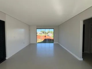 Espaço interno amplo com piso de cerâmica e porta de vidro voltada para o exterior.