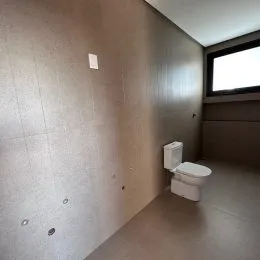 Vista interna de um corredor com paredes de cor neutra.