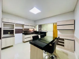 Vista da cozinha moderna com armários e bancadas em Lajeado.