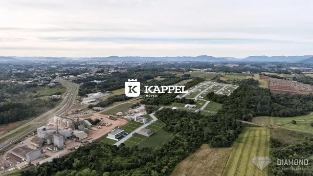 Vista aérea de um complexo industrial com infraestrutura e áreas verdes.