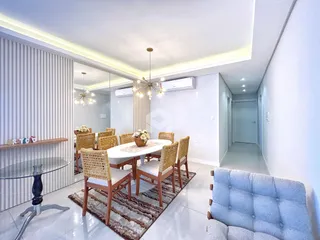 Ambiente de jantar com mesa de madeira e cadeiras em um apartamento em Lajeado.