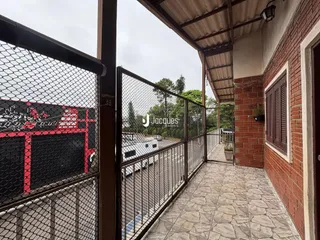 Vista de uma área externa com piso de cerâmica e cerca de metal em uma propriedade em Lajeado.