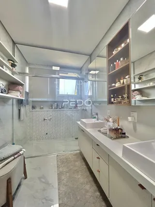 Interior de um banheiro com revestimento branco e bancada clara.