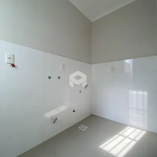 Parede interna branca com piso claro em uma residência.