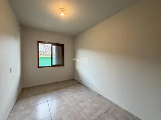 Vista interna de um cômodo com piso de cerâmica e janela.