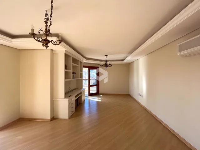 Sala ampla com piso de madeira clara e paredes brancas.