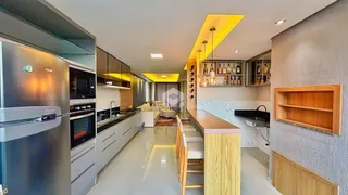 A cozinha moderna apresenta armários e uma ilha central.