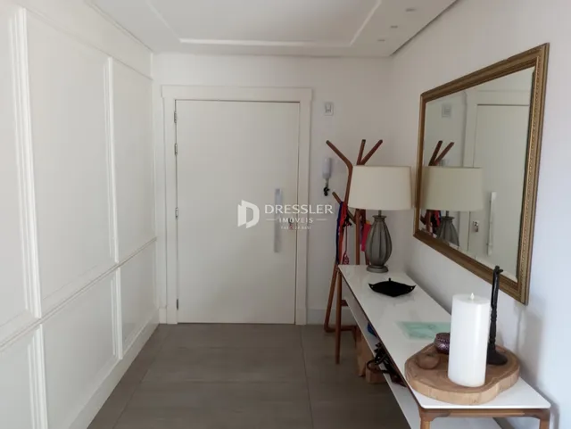 Hall de entrada com portas brancas e espelho decorativo.