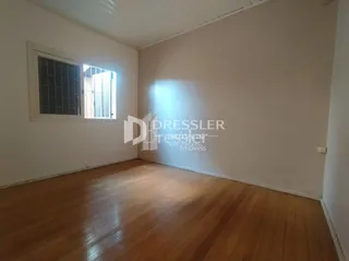 Ambiente interno com piso de madeira e janela.